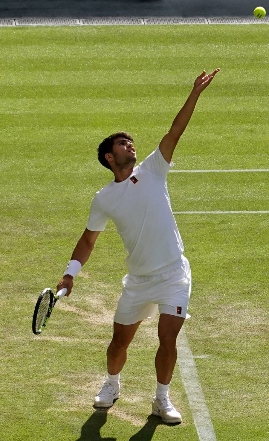 Carlos Alcaraz sacando em Wimbledon 2025